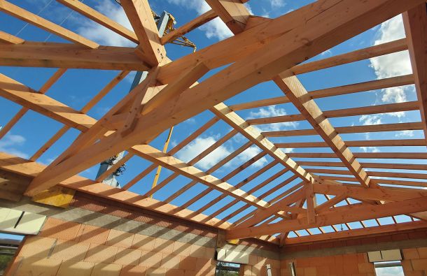 Artisan SF Toiture installant une nouvelle charpente en bois lors d'un chantier d'arasement sur une maison traditionnelle dans la Loire